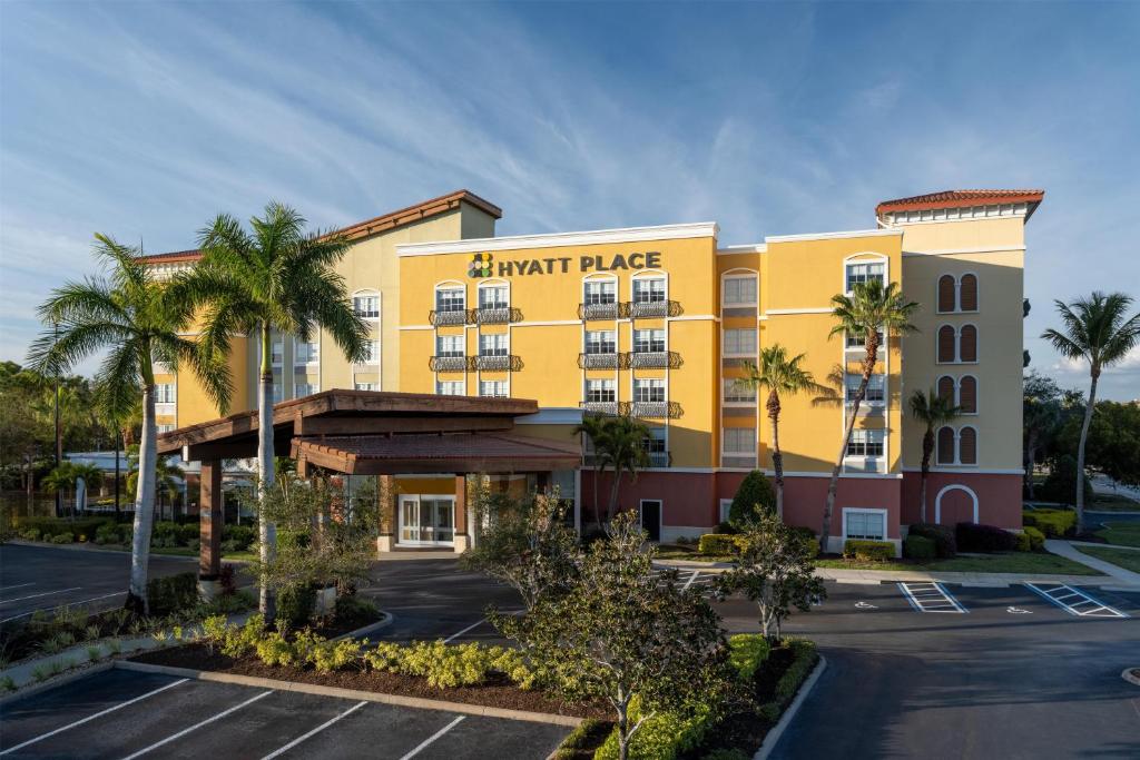 a large yellow building with a parking lot at Hyatt Place Fort Myers Estero - Newly Renovated in Estero