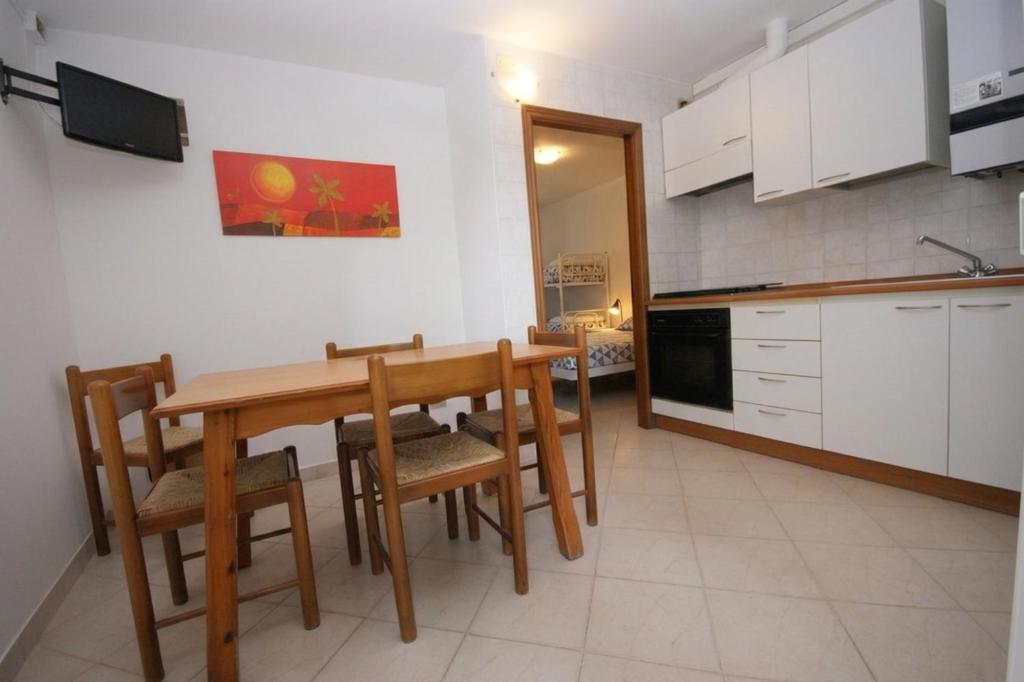 a kitchen with a wooden table and chairs at 67 Bellaria Bilocale vicino al mare in Bellaria-Igea Marina