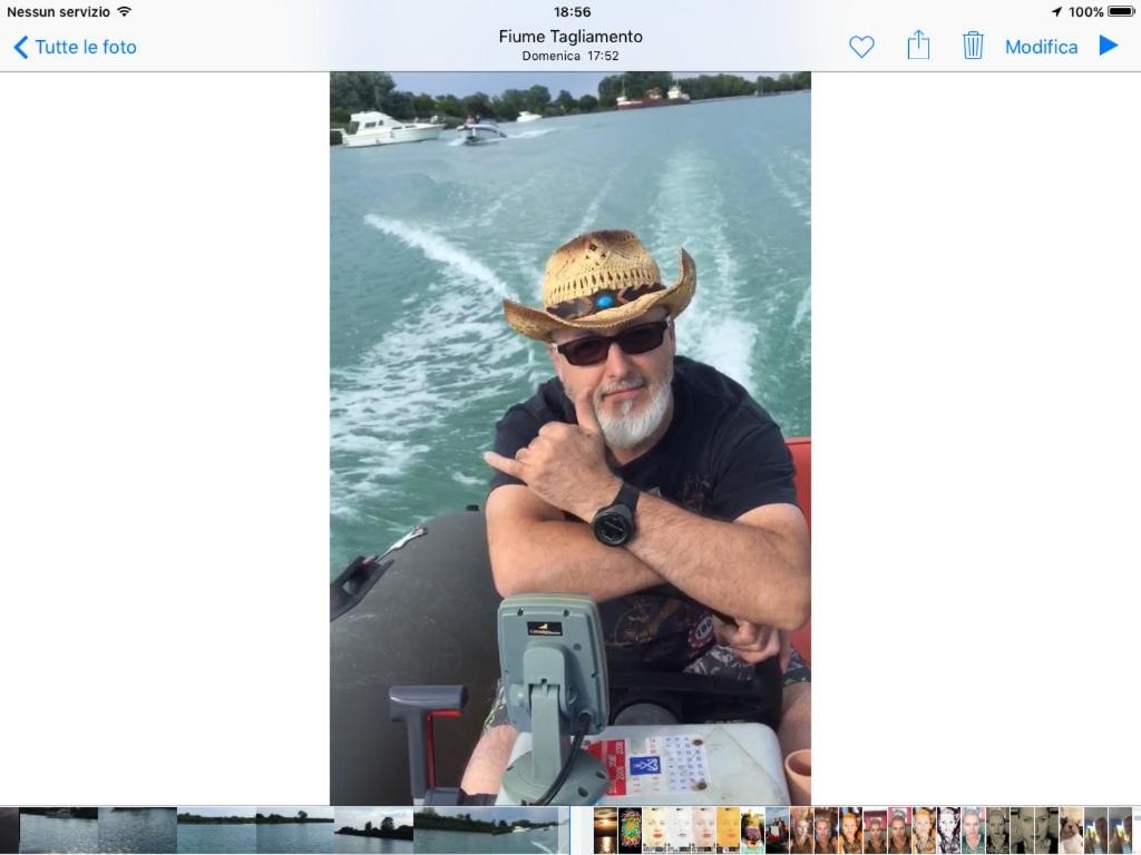 a man in a hat on a boat on the water at Augusta Palm Apartment in Bibione