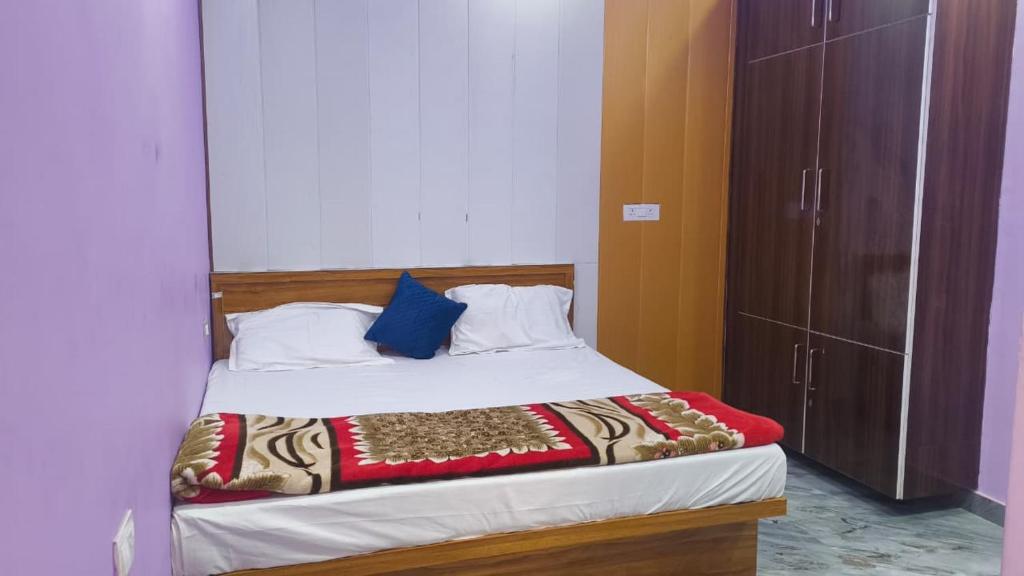 a bedroom with a large bed with a blue pillow at Janki Guest House in New Delhi