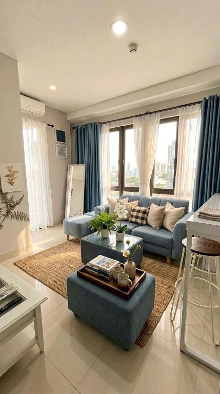 a living room with a blue couch and a table at Sky High City View 2BR Corner Condomonium in Pulau Sembakau Kecil