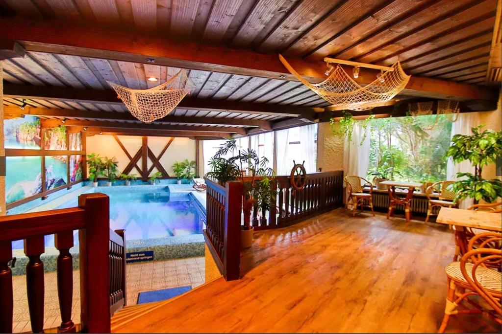 a large room with a swimming pool and hammocks at Haus Zellerwirt in Ruhpolding