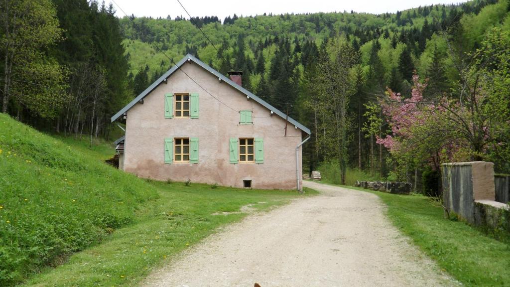 a house on a hill next to a dirt road at Gîte de Très Bayard in Saint-Claude