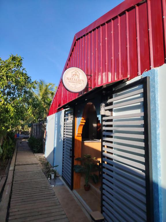 a building with two garage doors and a sign on it at Natalie's Homestay Bed and Breakfast in El Nido