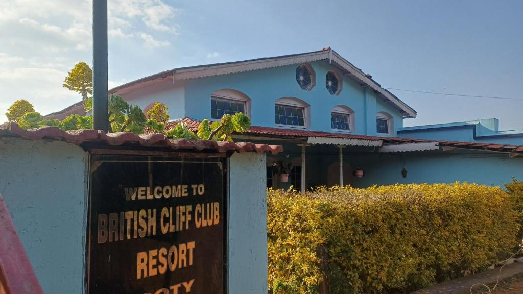 a building with a sign in front of it at Cliff Club Resort Ooty in Ooty