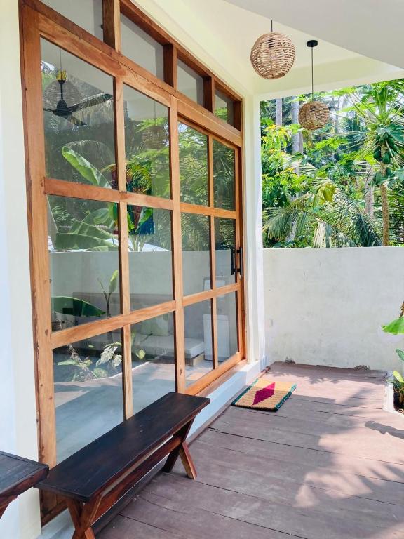 a porch with a bench and a large window at Layday Surf Ahangama in Ahangama