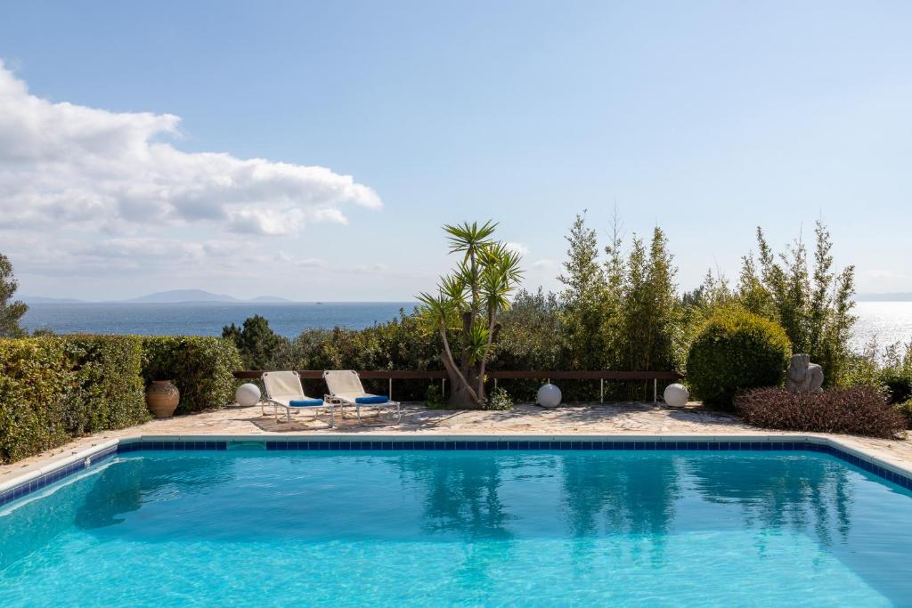 a swimming pool with a view of the ocean at Villa KATHERINA G in Schinias