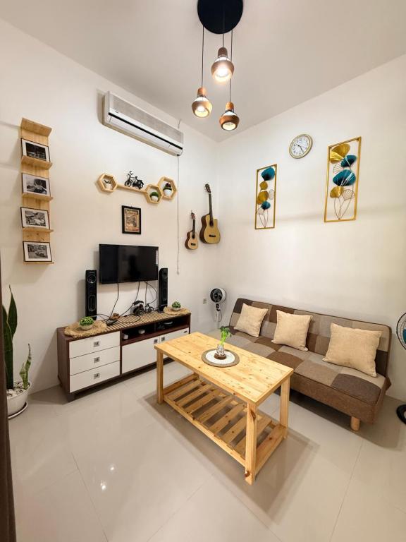 a living room with a couch and a table at The Heaven Luxe Pangandaran in Pangandaran