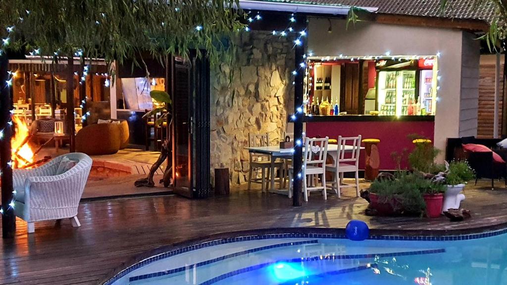 a pool in front of a restaurant with a bar at MALI Boutique Lodge & Tube 'n Axe Budget Accommodation in Stormsrivier