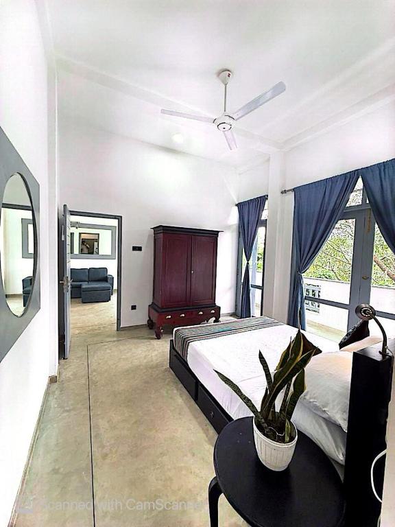a bedroom with a bed and a table with a plant at Far view villa in Galle