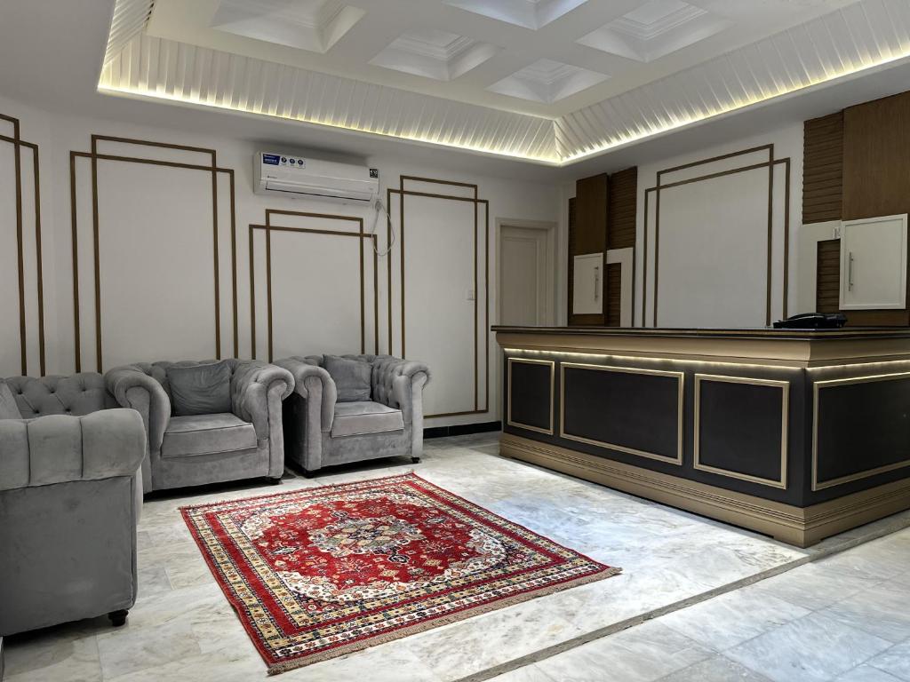 a living room with two chairs and a reception desk at Hotel Araamish in Peshawar