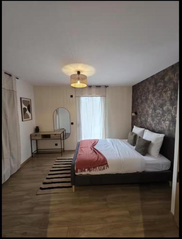 a bedroom with a bed and a table and a window at La costière in Nice