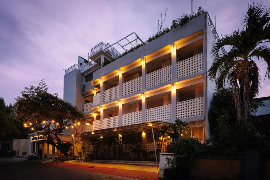a hotel with lights on the facade at night at Deva Bali Apartement in Kerobokan