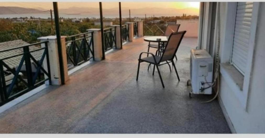 a balcony with two chairs and a table on it at MOSXONAS House in Áyioi Asómatoi