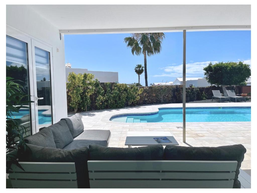 a living room with a couch and a swimming pool at Villa Infinity Exclusive in Tías