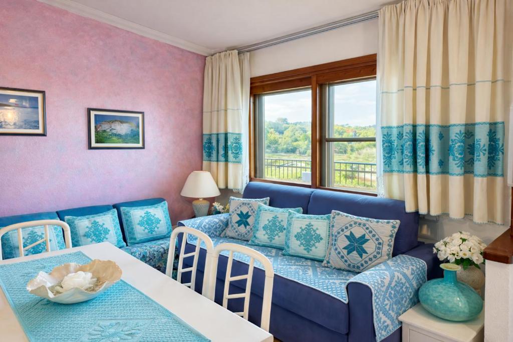 a living room with a blue couch and a table at Casa Lucia vicino al mare in Budoni