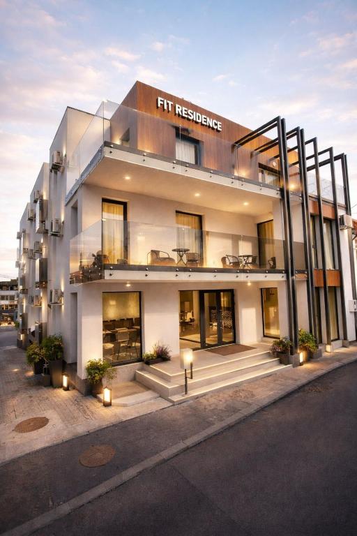 a tall white building with a sign on it at Fit Residence Hasdeu in Cluj-Napoca
