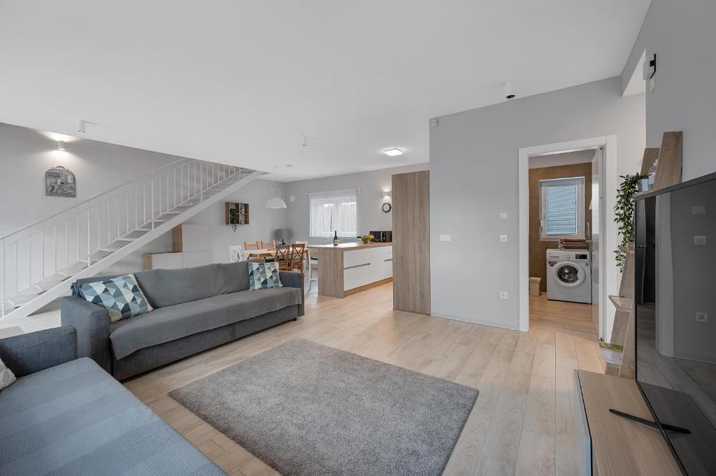 a living room with a couch and a staircase at House Degenia in Lovinac