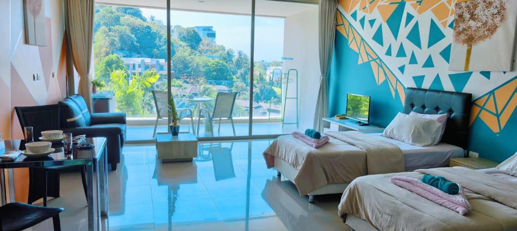 a hotel room with two beds and a living room at Veloche Karon 12 in Karon Beach