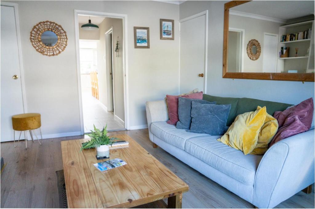 a living room with a blue couch and a wooden table at Moat View Donaghadee in Donaghadee