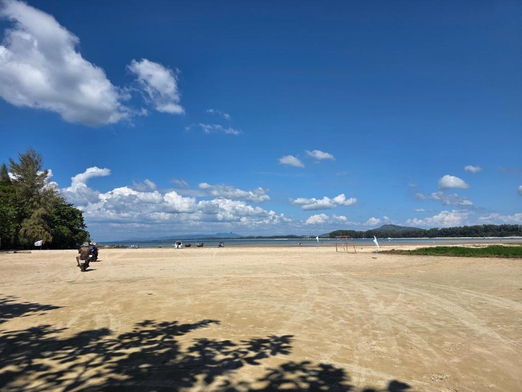 a person riding a motorcycle on a sandy beach at Luangwang Resort in Nai Yang Beach