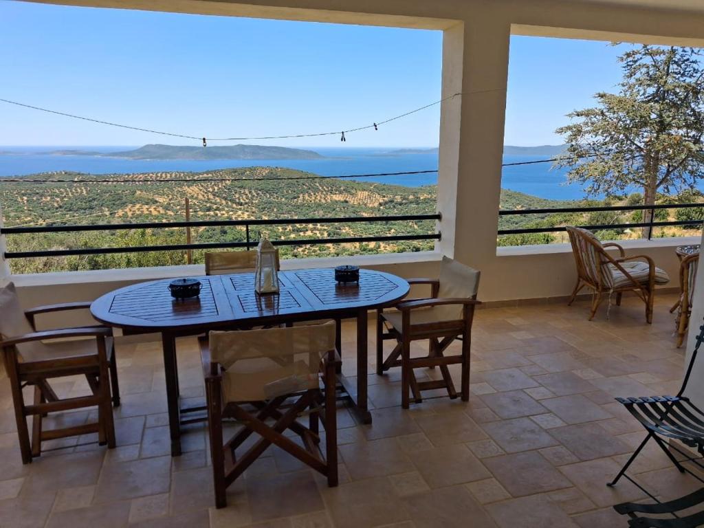 a dining room with a table and chairs and a large window at Big Terrace 180 view to sea in Akritokhórion