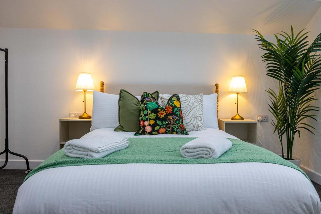 a bedroom with a large white bed with two lamps at The Knutsford loft in Knutsford