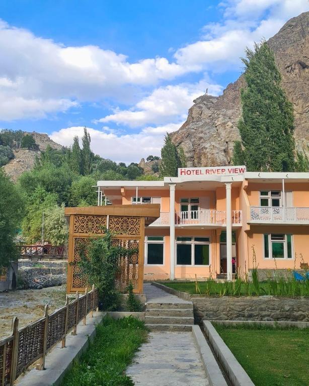 a hotel near a river with mountains in the background at River View Hotel Shigar in Shigar