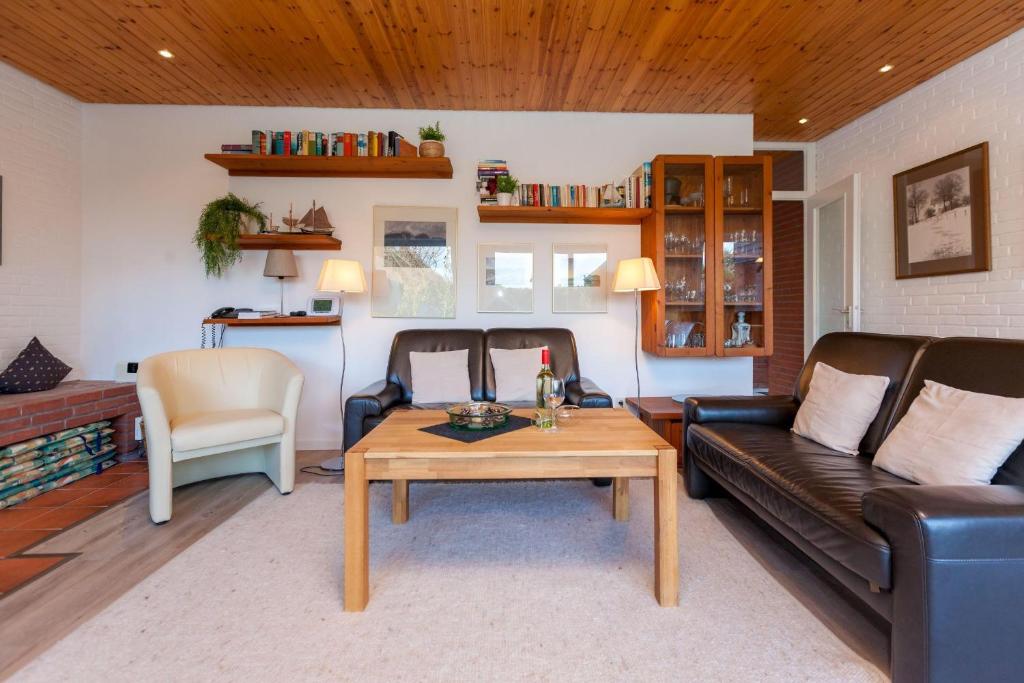 a living room with a couch and a table at Bungalow-Finlandia in Westerland