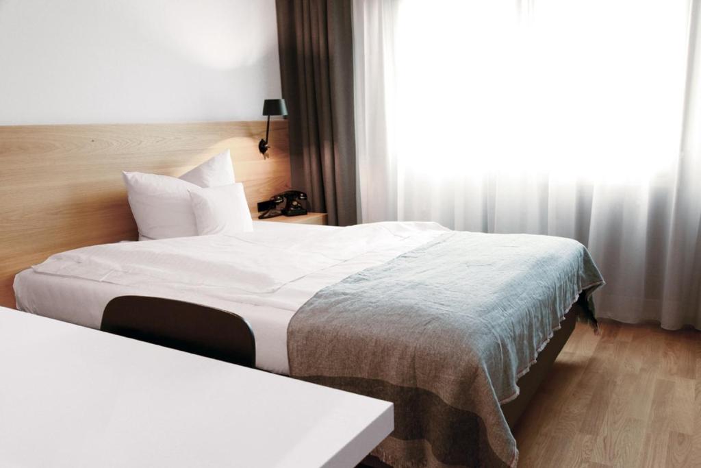 バーリンゲンにあるホテル シュタット バーリンゲンのベッド2台と窓が備わるホテルルームです。