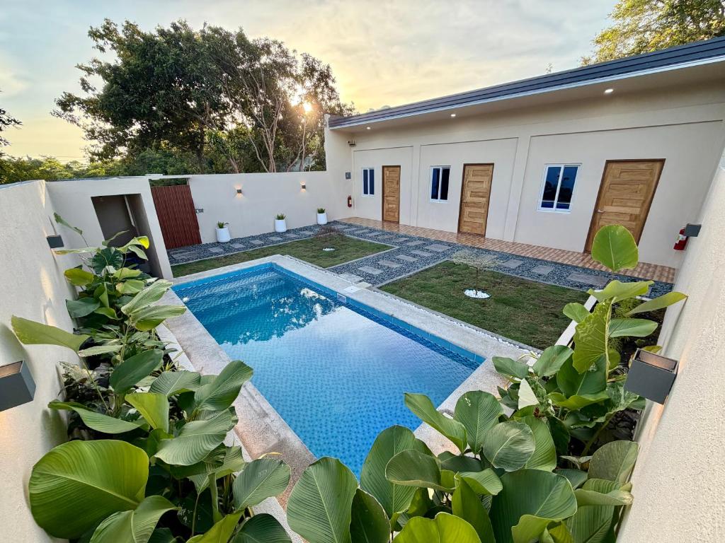 a pool in the backyard of a house with plants at Siquijor Travellers Inn in Siquijor