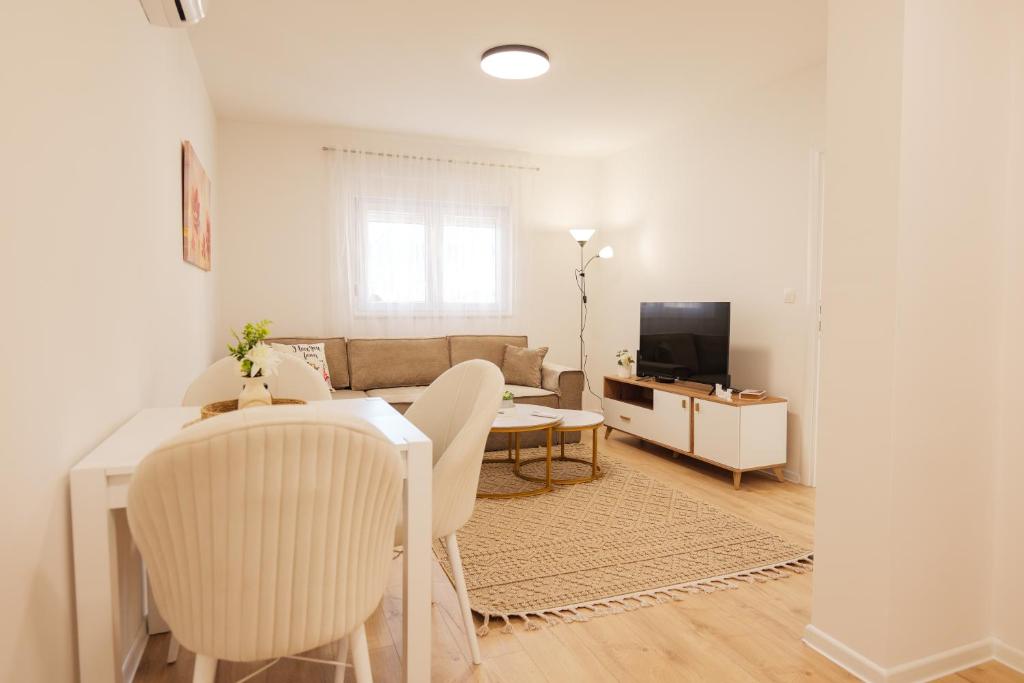 a living room with a table and a couch at Apartmani Otium in Mostar