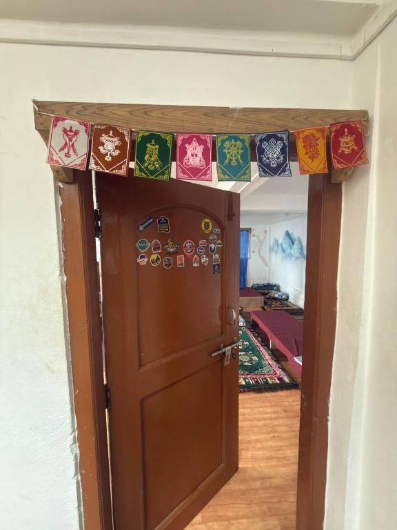 a door with a bunch of stickers on it at Tashi Delek Hostel & Homestay in Tawang