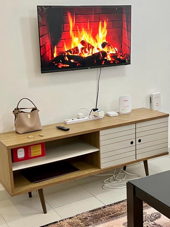 a fireplace in a living room with a tv on the wall at Leona Homes in Mombasa