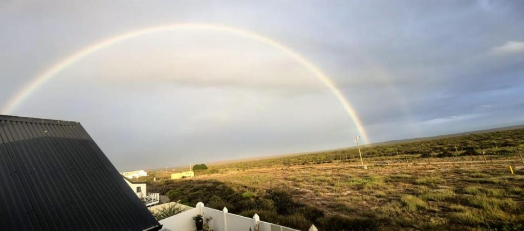 a rainbow in the sky over a field at The Gables in Grotto Bay