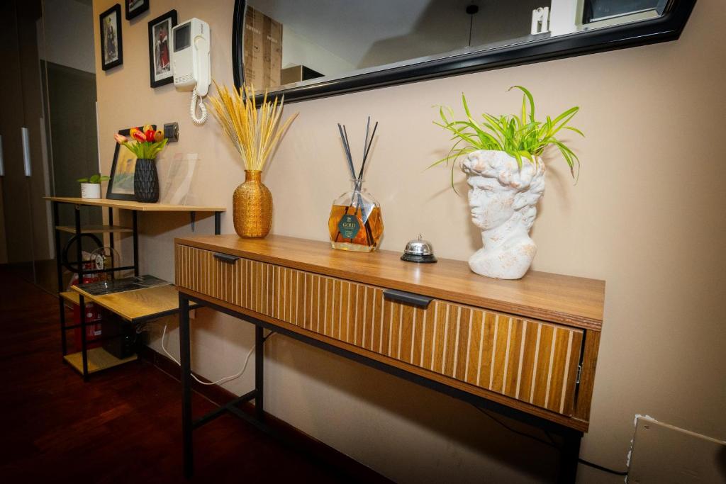 a table with vases and plants on a wall at Dimora Nicotera in Lamezia Terme