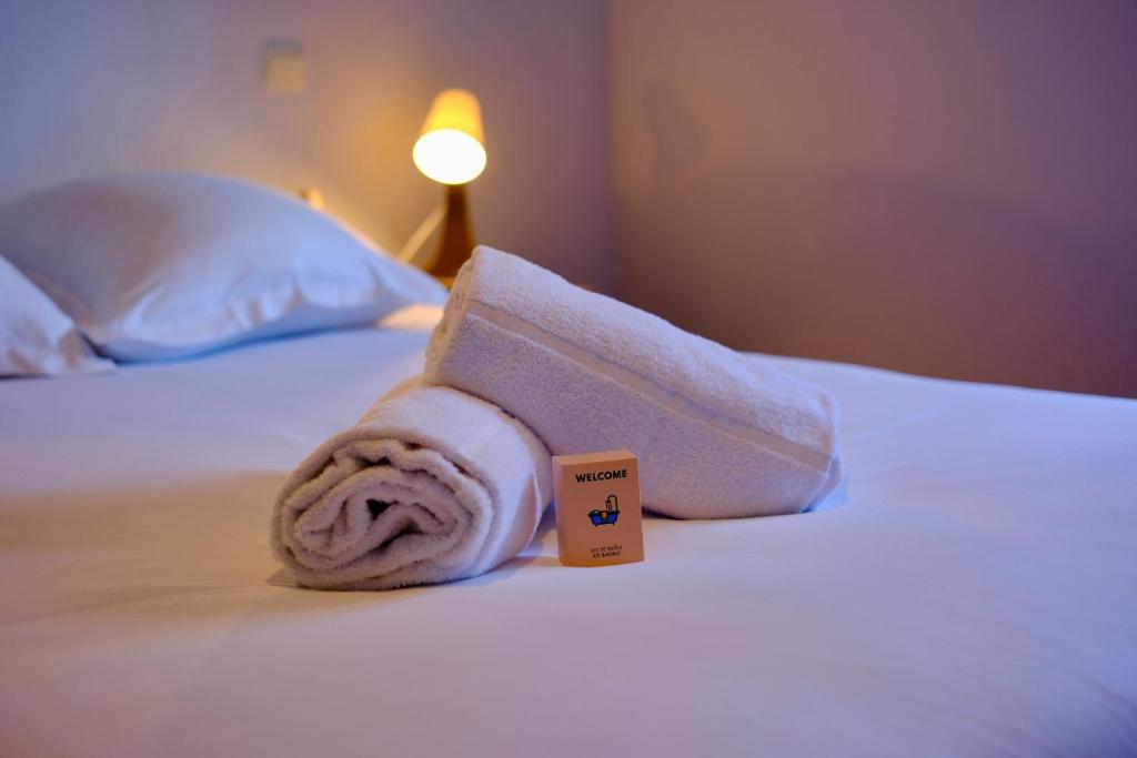 a rolled up towel on a bed in a hotel room at Le toit des Carmes in Rouen