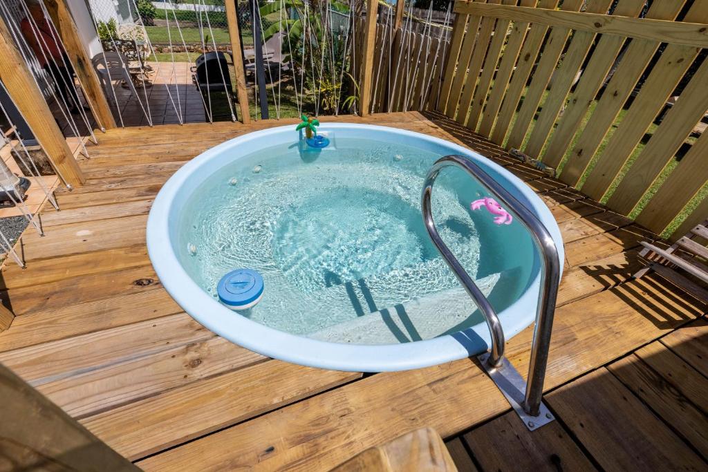 a bath tub on a wooden deck with at Cozy house with sea view! in Luquillo