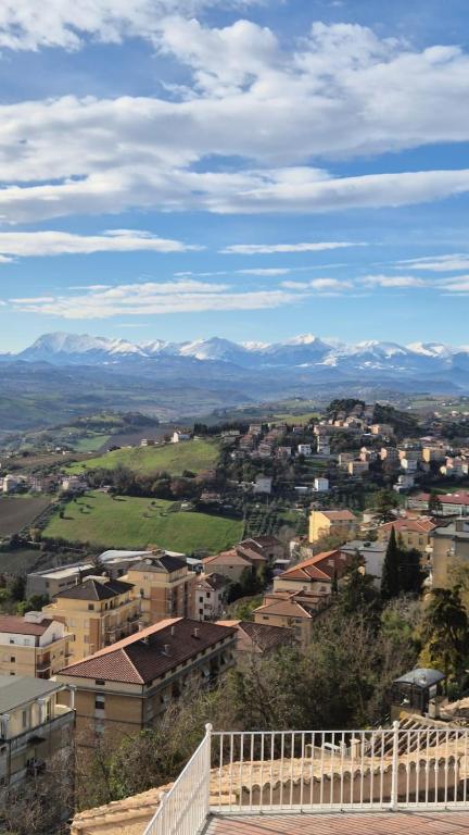 a city with snow capped mountains in the distance at B&B Falconi in Fermo