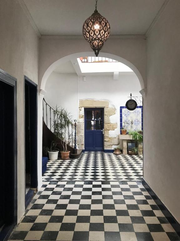 a hallway with a checkered floor and a blue door at Gîte de l'oiseau bleu in Lautrec