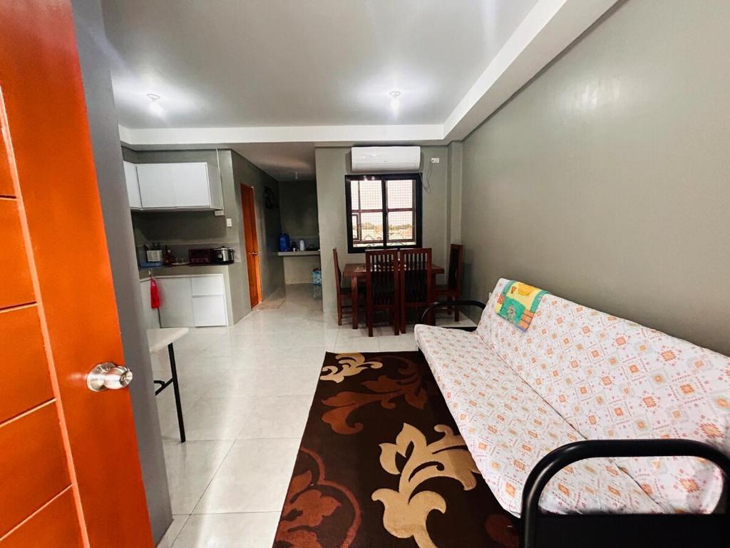 a small room with a couch and a kitchen at Dories Residences - Unit 6 in Pozorrubio