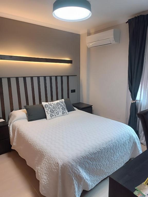 a bedroom with a large bed with a white comforter at Motel Mary in Jávea