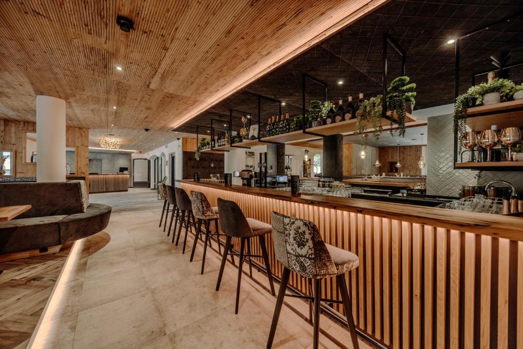a bar with a row of chairs in a restaurant at Resl Resort in Flachau