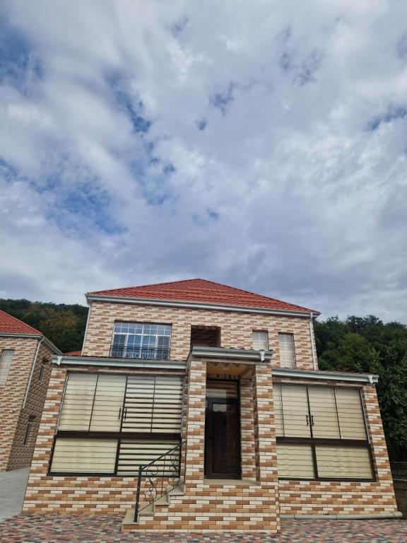 a brick building with two windows and a cloudy sky at Brick Villas in Qusar