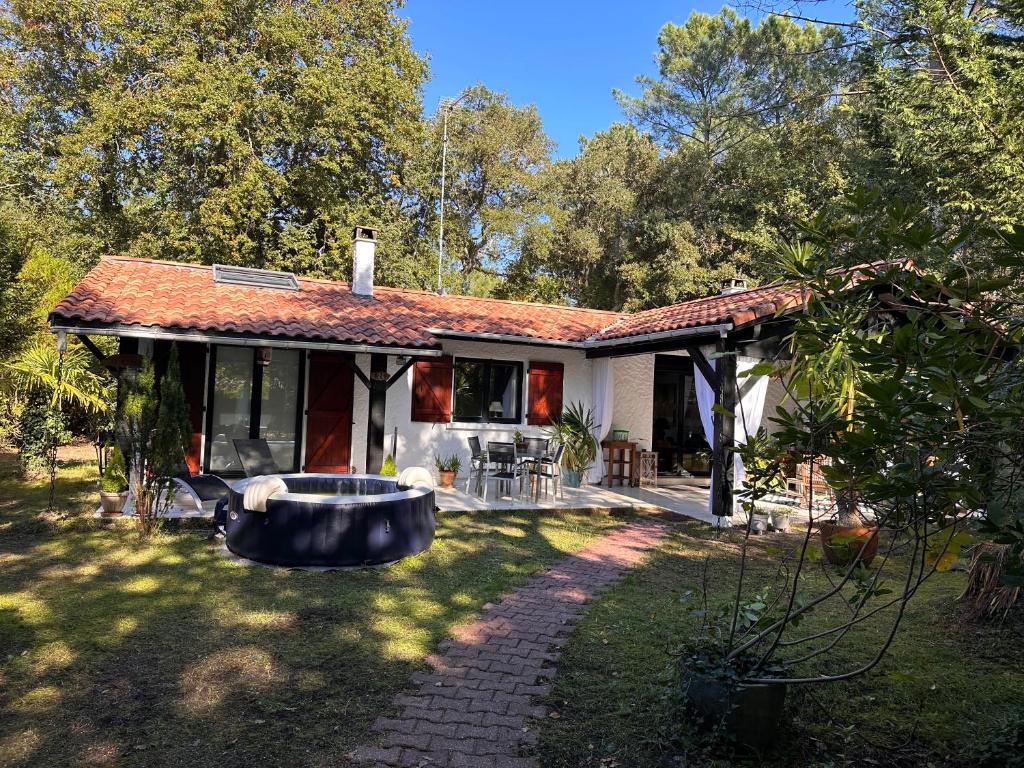 a small house with a large tub in the yard at La Becada de las Landas in Seignosse