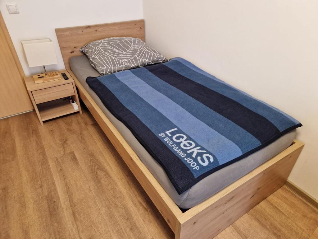 a bed with a blue blanket on top of it at Einzelzimmer in ruhiger Lage --- Check-In mit Schlüsselkasten in Meppen