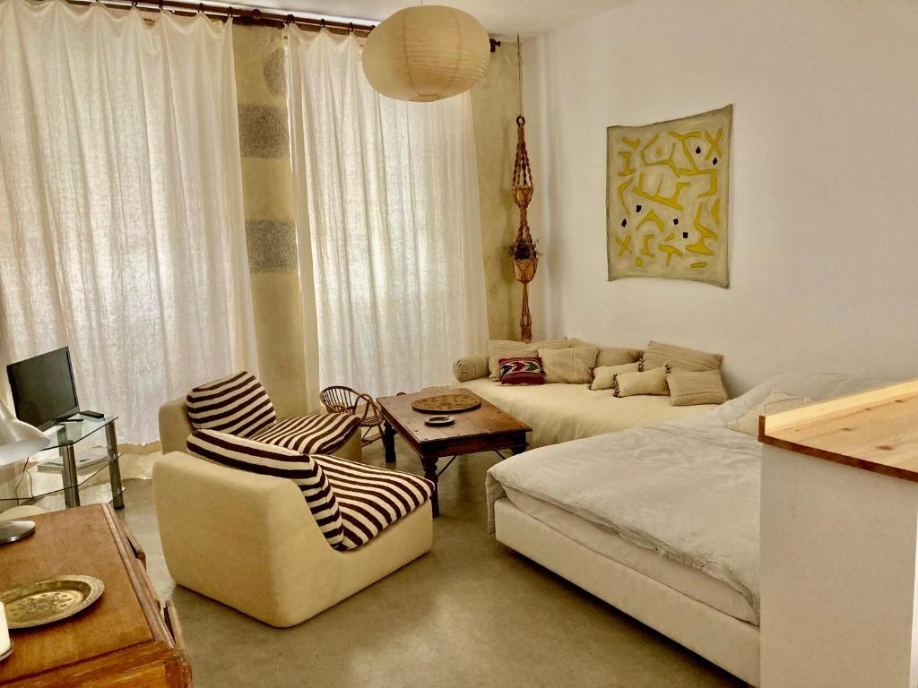 a living room with a bed and a couch at Studio à l'entrée de ma maison in Aubusson