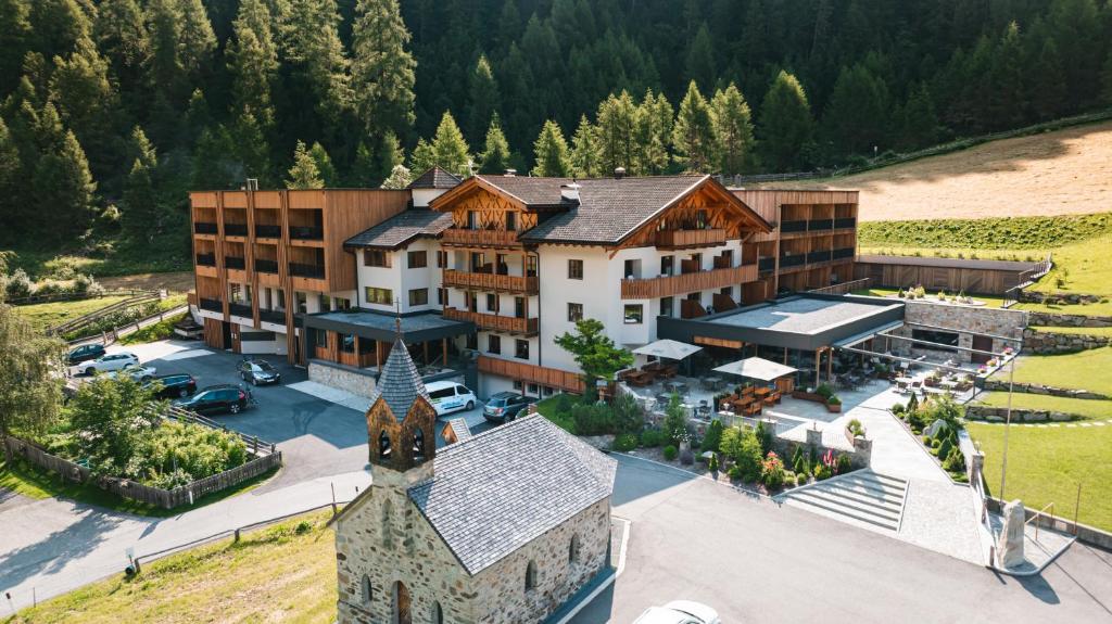 an aerial view of a large building with a church at Almhotel Glieshof in Malles Venosta