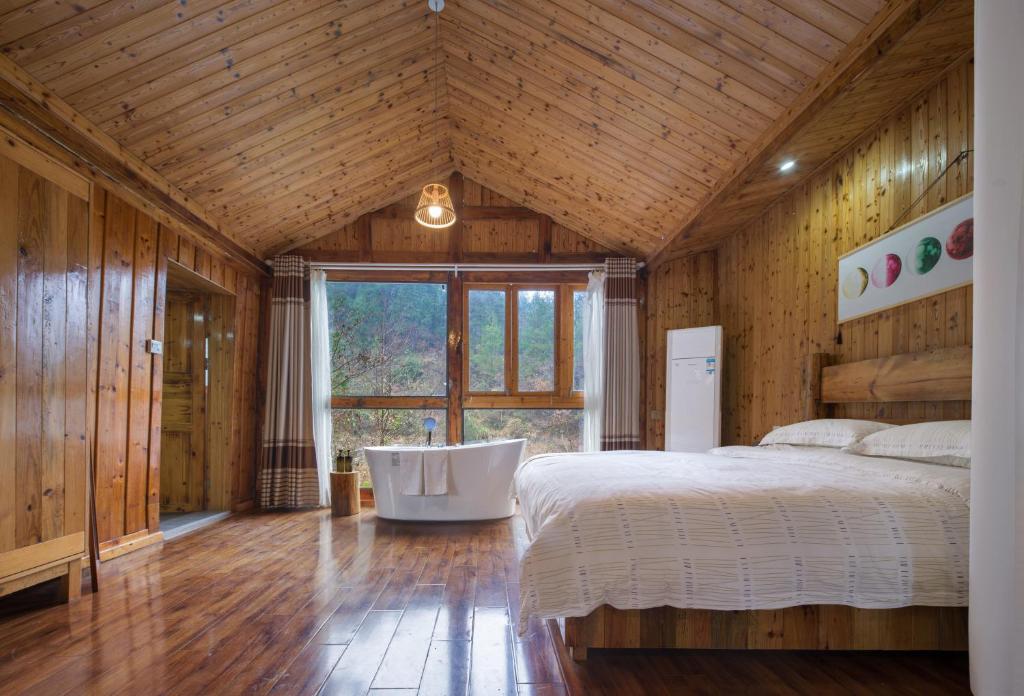 a bedroom with a bed and a large window at Astria Moruo Retreat in Xinglong