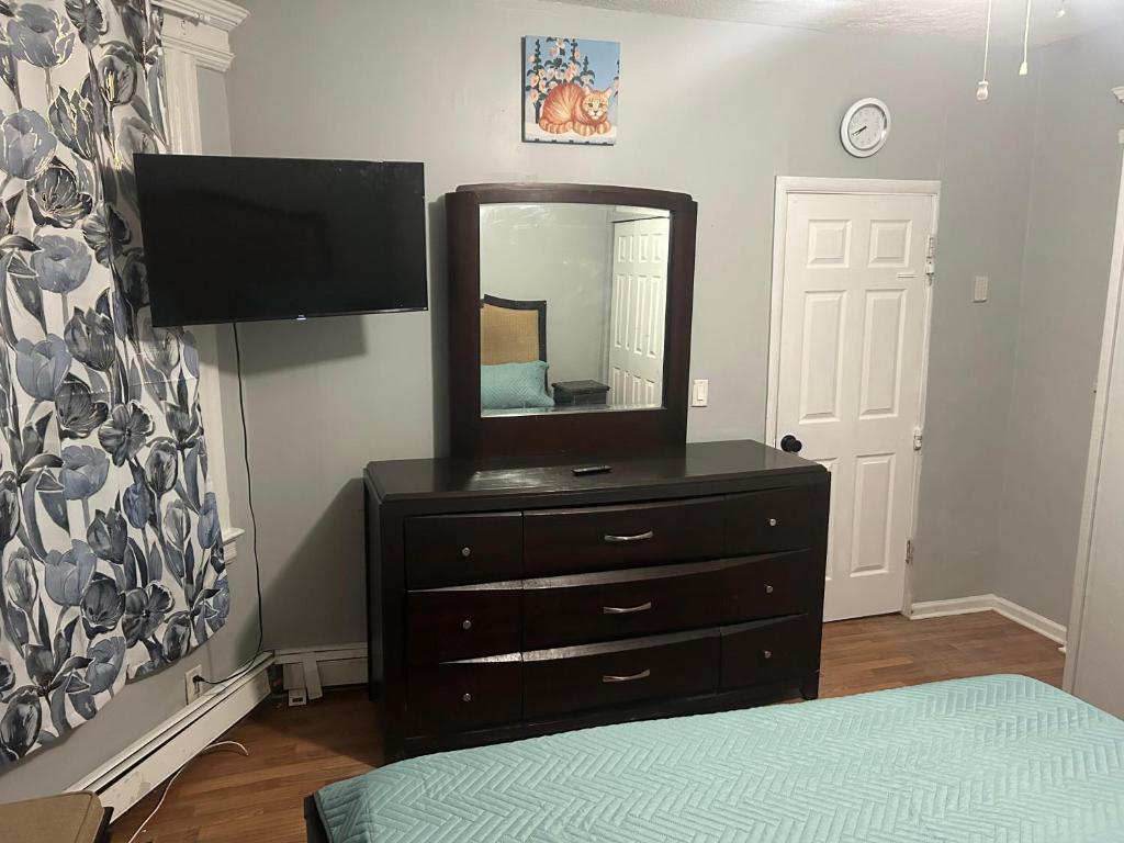 a bedroom with a dresser with a mirror on it at Grove#8 in Irvington